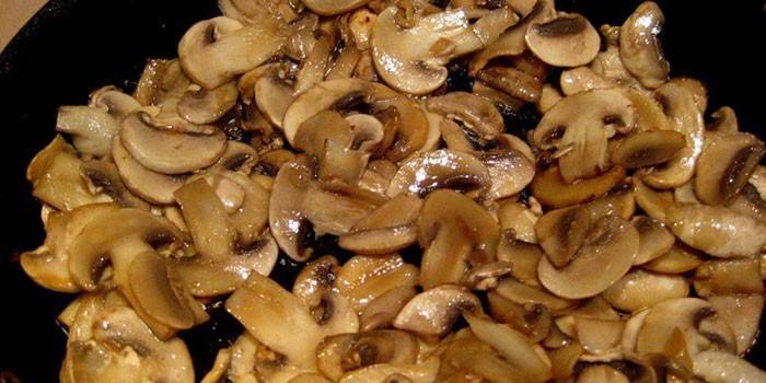 Champiñones rebanados fritos en una sartén