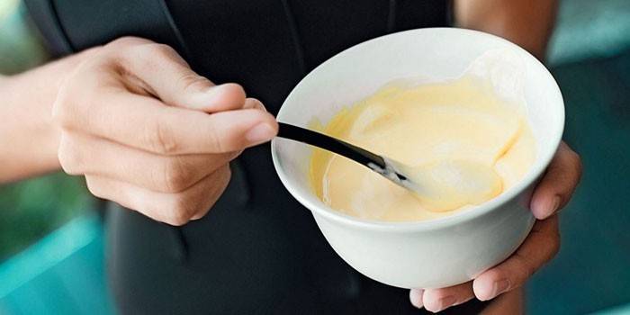 Menina mistura kefir com limão em um prato