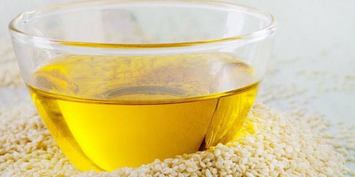 Aceite de sésamo en una placa de vidrio y semillas de sésamo