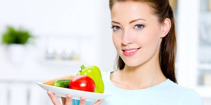 Niña sostiene un plato en la mano con verduras