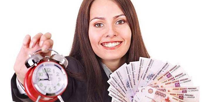 Chica con dinero y un despertador en las manos.
