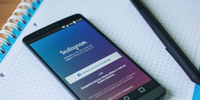 Aplicativo Instagram no telefone, caderno e caneta