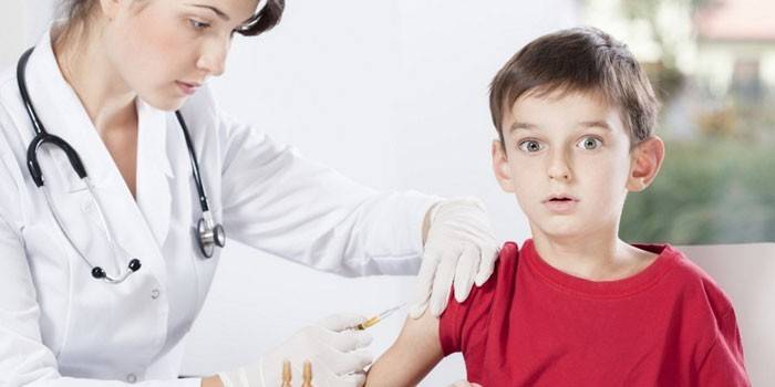 O médico dá a criança uma injeção