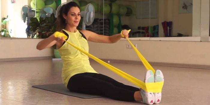 Menina fazendo exercícios no chão com fita