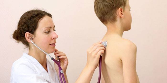 O médico ouve os pulmões do menino