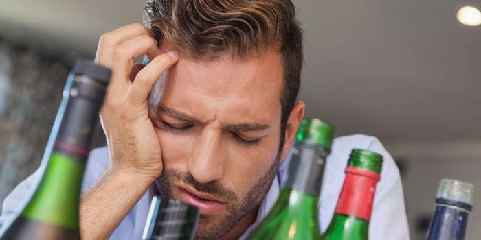 Muž a fľaša alkoholu