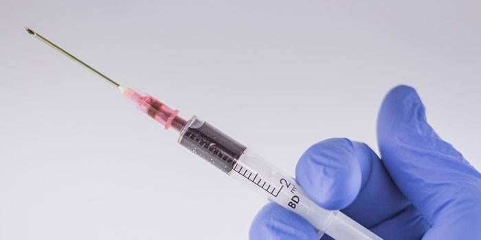 Jeringa con sangre en mano