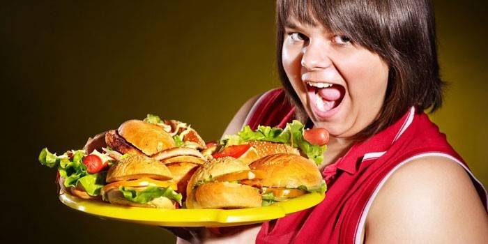 Mujer sostiene una bandeja con hamburguesas