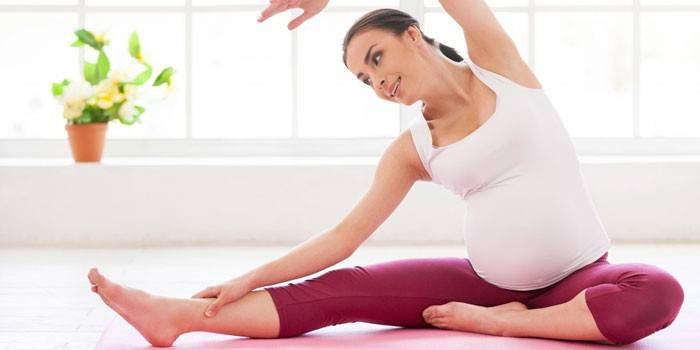 Ciężarna dziewczyna robi pilates w domu