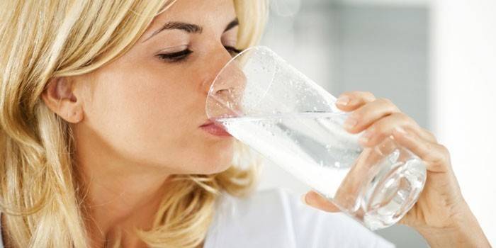 Niña bebe agua de un vaso