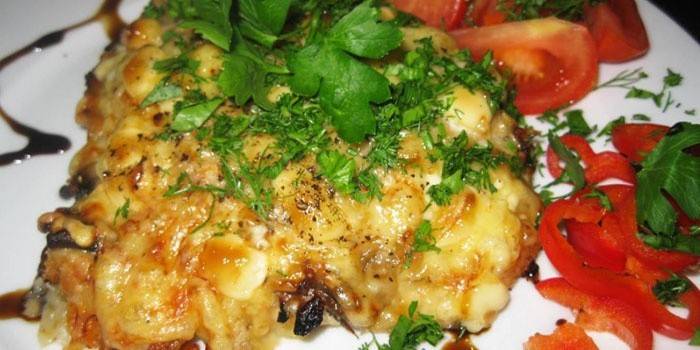 Frango assado com cogumelos em um prato com legumes