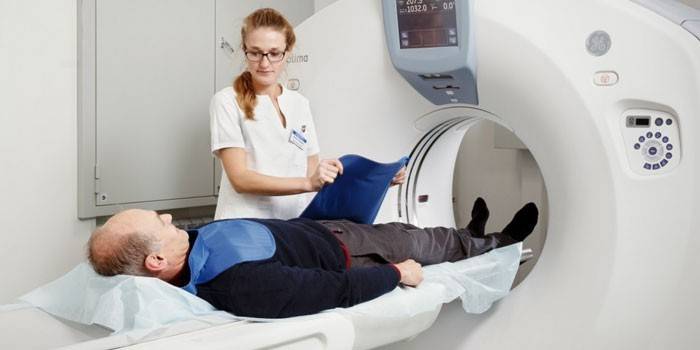 Mężczyzna w aparacie do tomografii komputerowej i ratownik medyczny