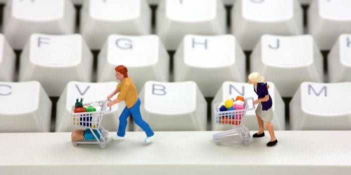 Hombres con cestas de compras en un teclado de computadora