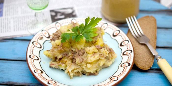 Purê de batatas com guisado em um prato