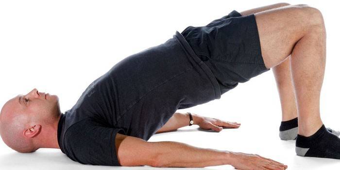 O cara realiza o exercício da ponte glútea
