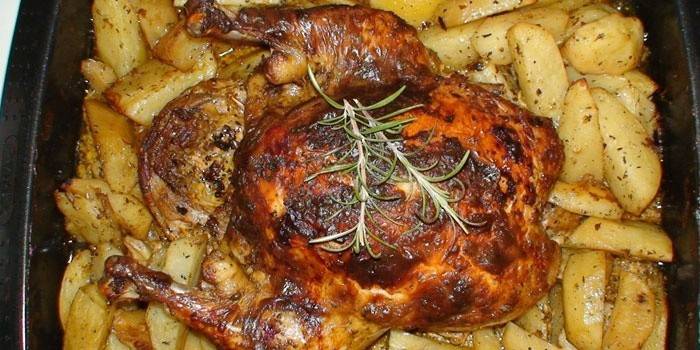 Pollo sobre una almohada de patata sobre una bandeja para hornear