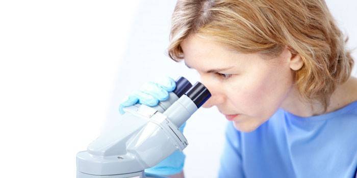 Niña mirando a través de un microscopio