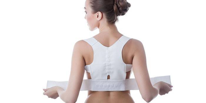 Chica en un corsé para la columna vertebral
