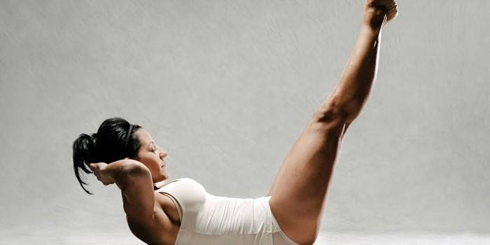 Dievča vykonáva cvičenie Pilates pre brucho.