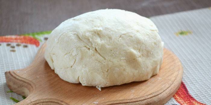 Un tazón de masa de crema pastelera sobre una tabla para cortar