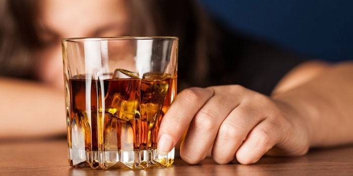 Žena s pohárom whisky v ruke