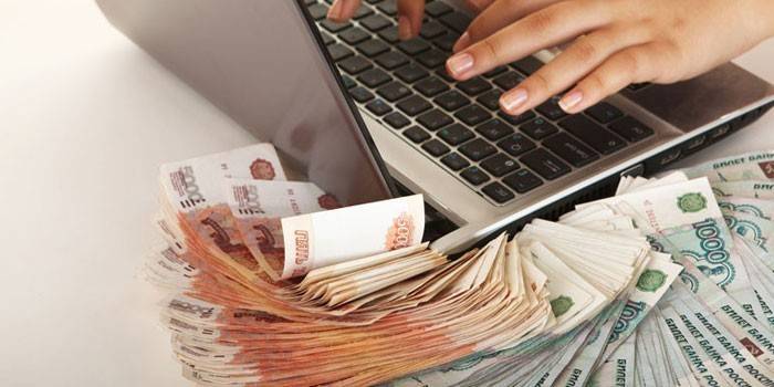 Garota em um laptop e dinheiro