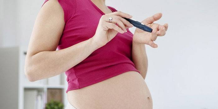 Menina grávida verifica o açúcar no sangue