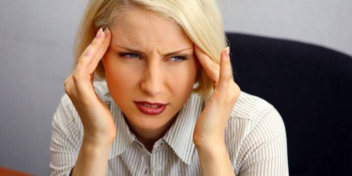 La mujer tiene dolor de cabeza.