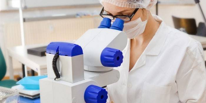 Médico olhando através de um microscópio