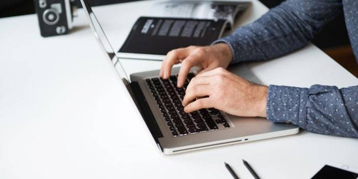 Un hombre trabaja en una computadora portátil