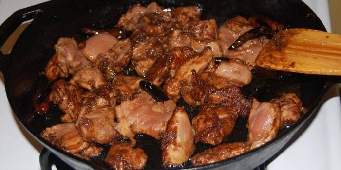 Trozos de pollo en salsa de soja en una sartén