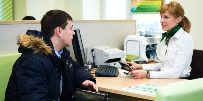 Um homem conversando com um funcionário do banco