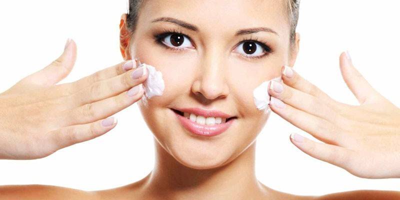 Chica pone crema en su cara