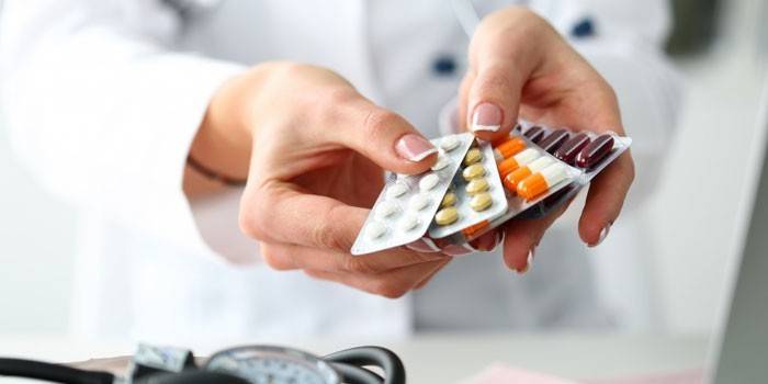 O médico tem um pacote de comprimidos nas mãos dele