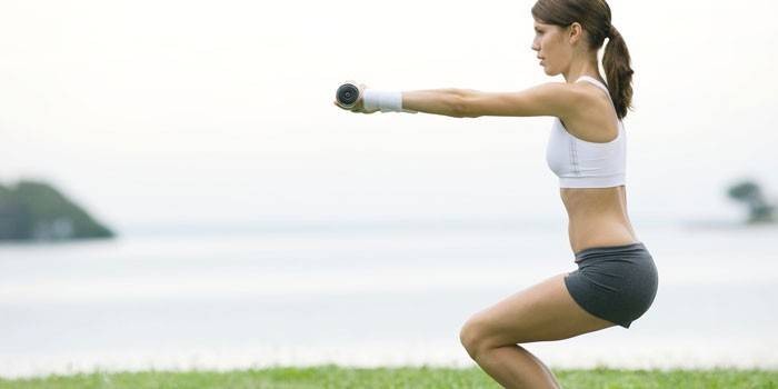 Menina, fazendo, exercício cadeira, com, dumbbells