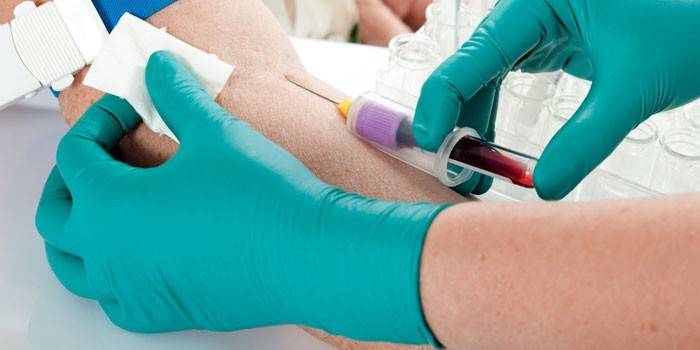Medic realiza uma amostragem de sangue de um paciente
