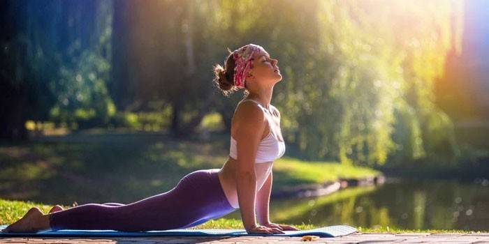 A menina dedica-se à ginástica na natureza