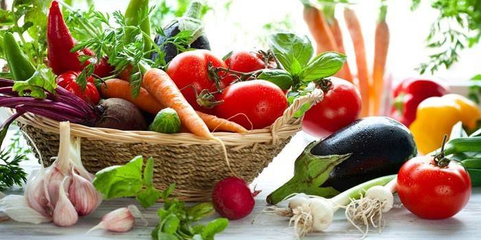 Verduras en la cesta y sobre la mesa