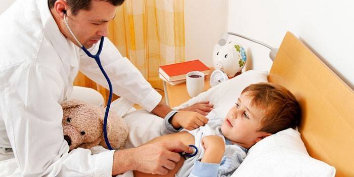 O médico escuta com um estetoscópio.