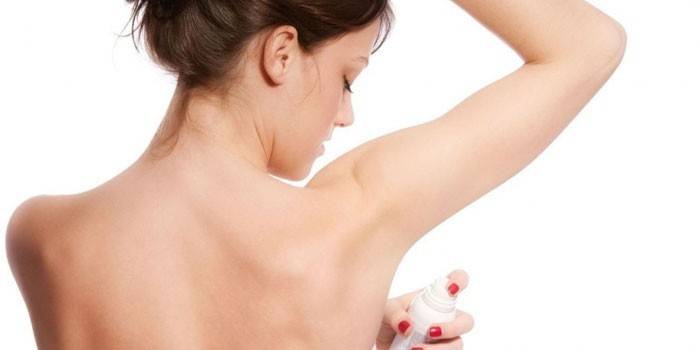 Dievča aplikuje deodorant na axilnú vrstvu spreja