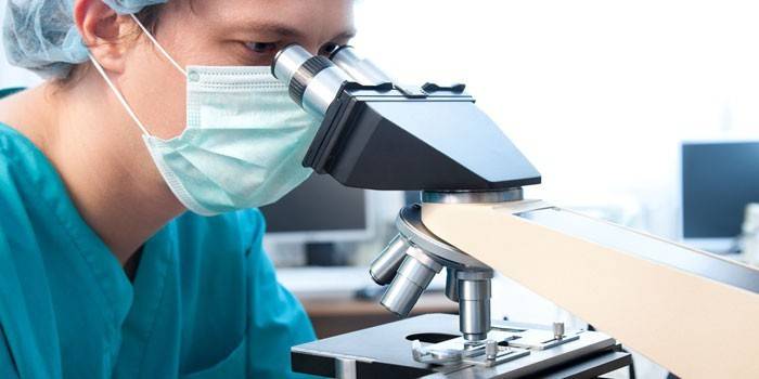 Médico mirando a través de un microscopio
