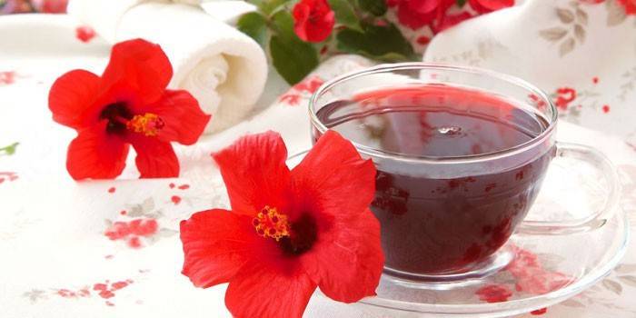 Té de hibisco en una taza y flores de hibisco