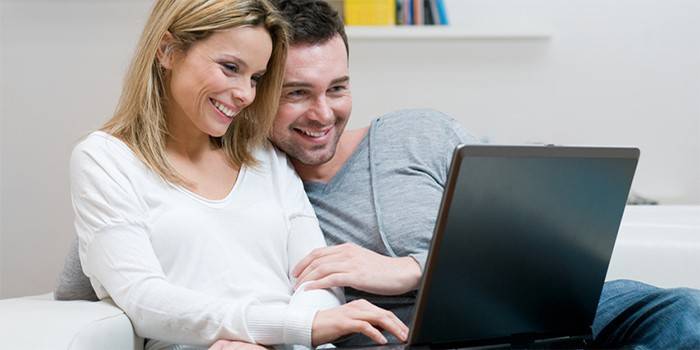 O cara e a garota estão olhando para o laptop