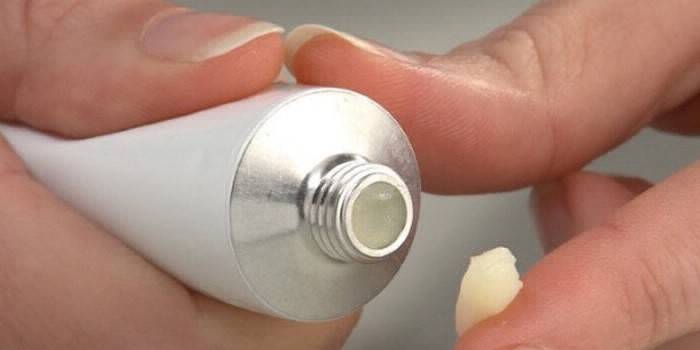 Tubo com pomada nas mãos