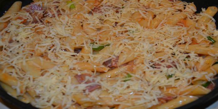 Penne com presunto e queijo em uma panela