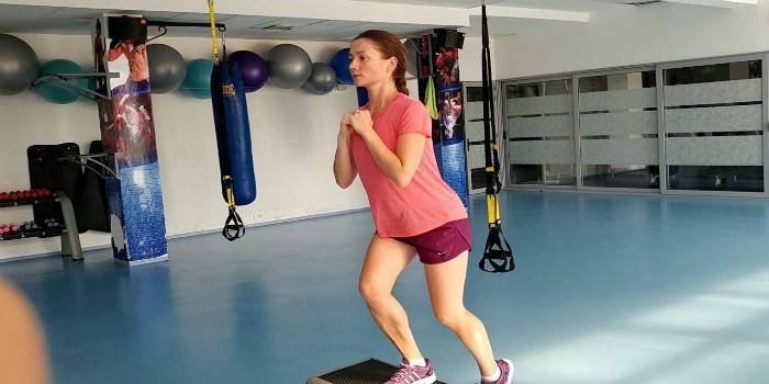 A garota realiza um exercício em uma plataforma de passo