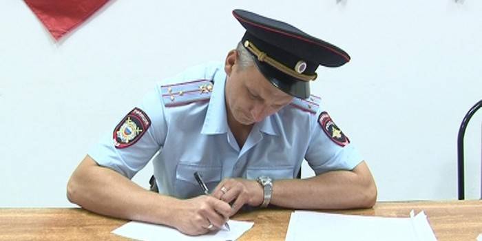 Policajt vypĺňa papier