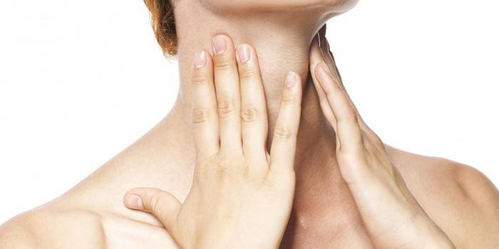 Mujer tiene las manos en el cuello.