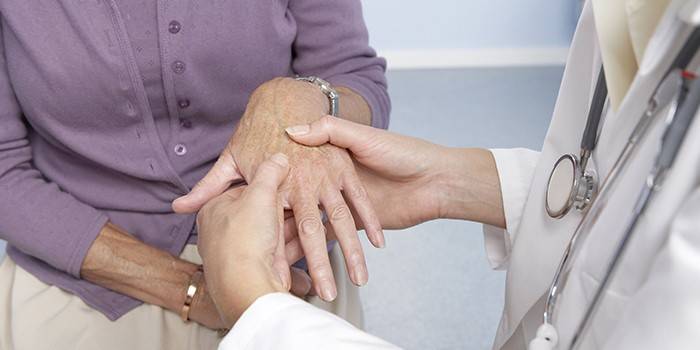 Médico examina a mão de uma mulher
