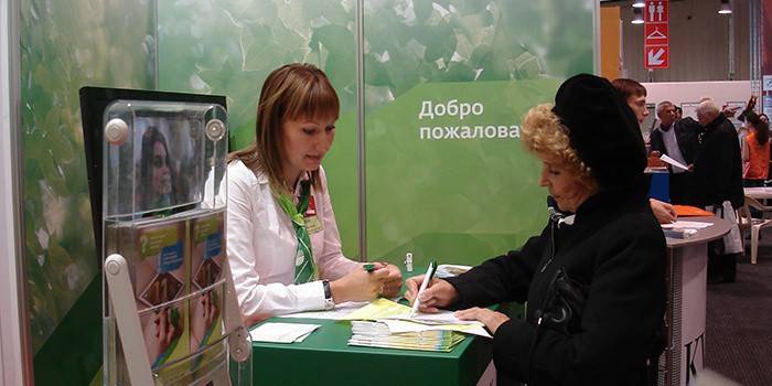 Kobieta wypełnia dokumenty w biurze banku